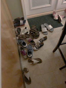 Several pairs of shoes piled by entryway